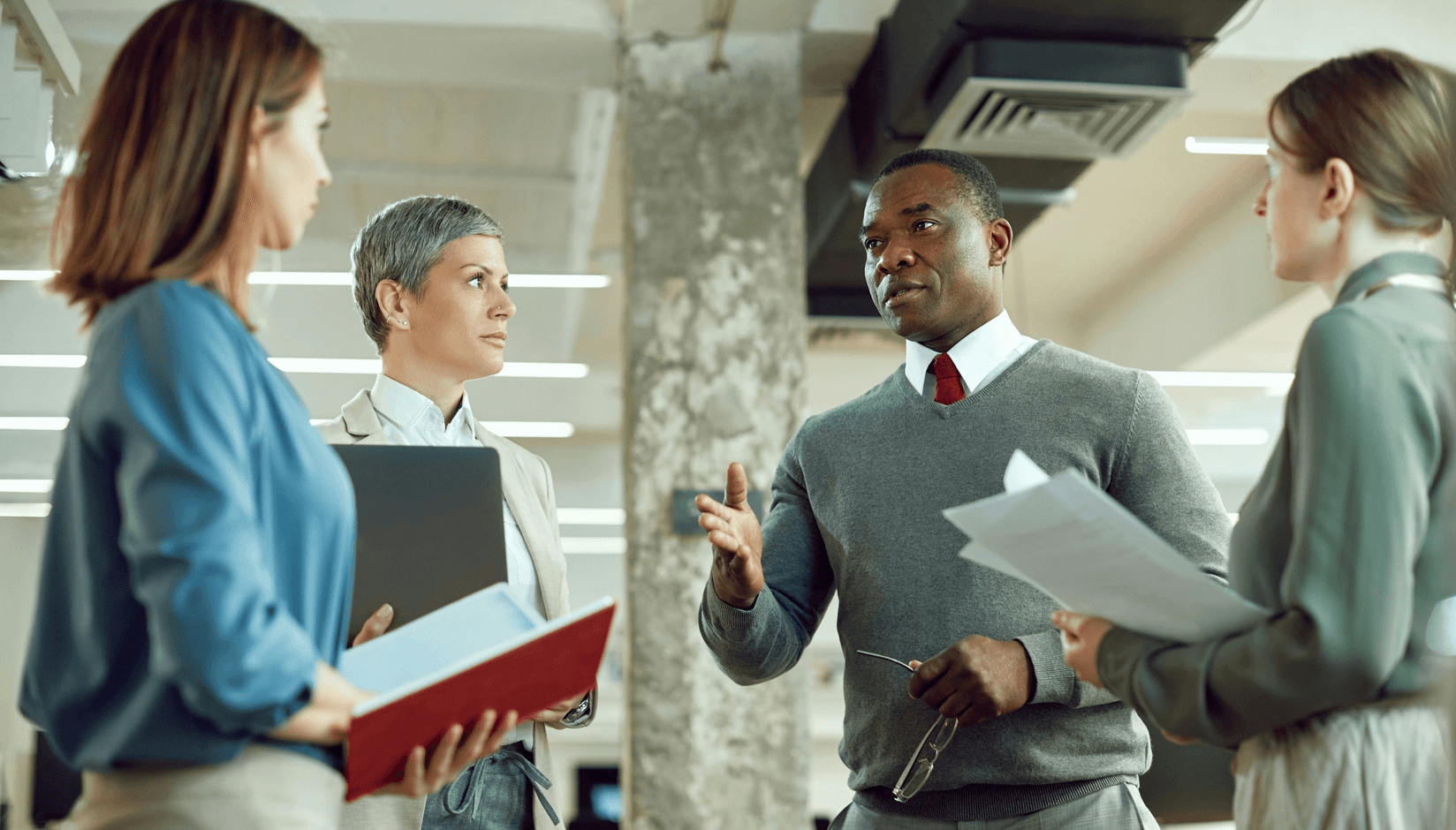small team with laptops working at the table in the coworking space